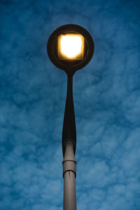 Low angle view of illuminated street light against sky