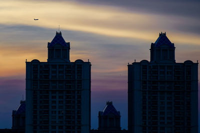 Low angle view of buildings against sky during sunset