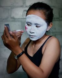 Close-up of woman applying face paint