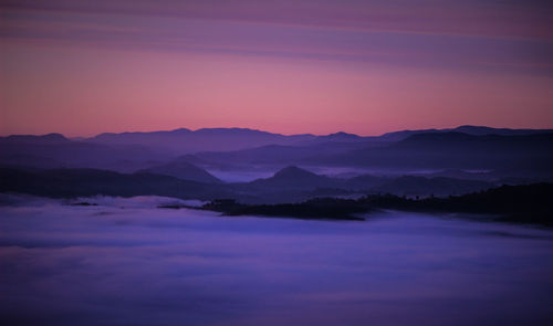 Scenic view of silhouette mountains against sky at sunset