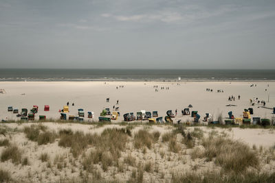 Group of people on beach against sky