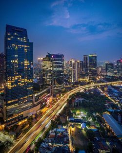 High angle view of illuminated city street and buildings at night