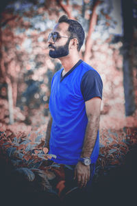 Young man looking away in forest