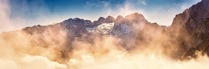 Panoramic view of majestic mountains against sky during sunset