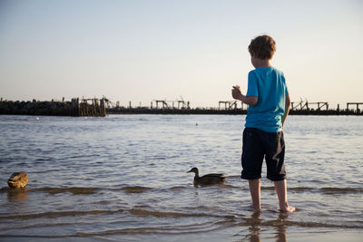 Full length of boy on shore against sky