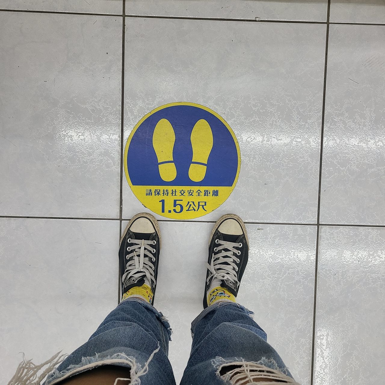 LOW SECTION OF MAN STANDING BY TEXT ON FLOOR