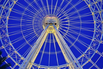 Low angle view of ferris wheel against blue sky