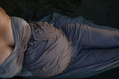 High angle view of pregnant woman lying in lake water