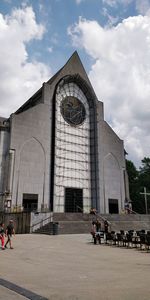 People in front of historic building against sky