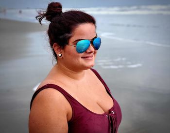 Portrait of woman wearing sunglasses at beach