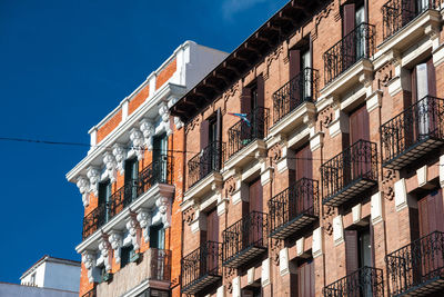 Low angle view of buildings against clear blue sky