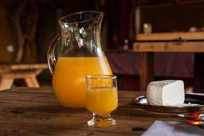 Close-up of fresh drink in jug with cottage cheese on table