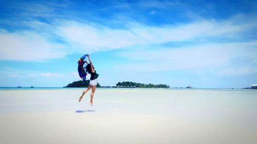 Full length of woman on beach against sky