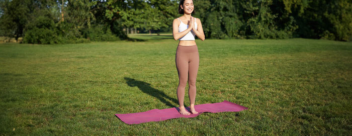 Full length of woman standing on grassy field