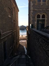 Footpath amidst buildings against sky