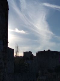 Low angle view of silhouette buildings against sky