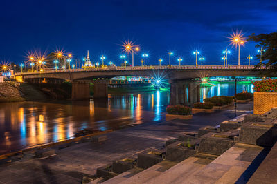Illuminated bridge over river at night