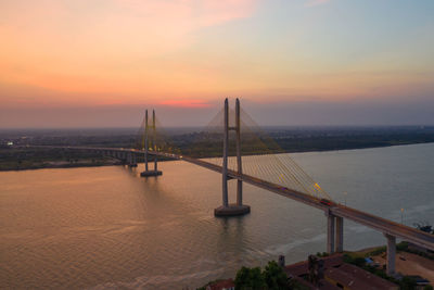 Bridge over sea against sky during sunset