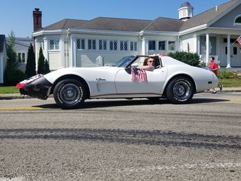 Side view of a car on road against buildings