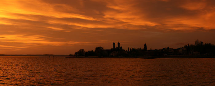 Scenic view of sea against dramatic sky during sunset