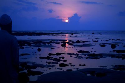 Silhouette man on beach against sky during sunset