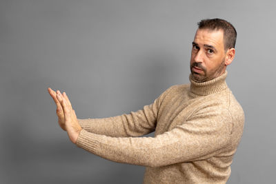 Portrait of young man standing against wall