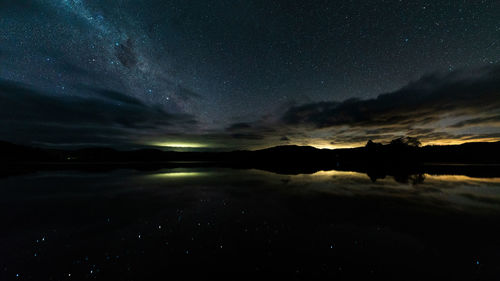 Scenic view of lake against sky at night