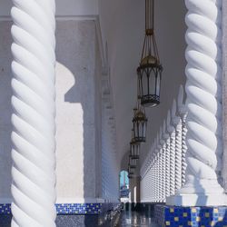 Illuminated lights hanging from ceiling of building against sky