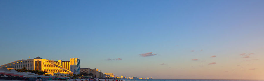 Buildings in city against sky during sunset