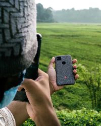Midsection of person photographing on field