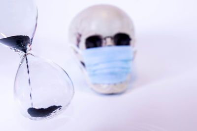 Close-up of crystal ball on glass against white background