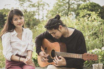 Young couple playing guitar