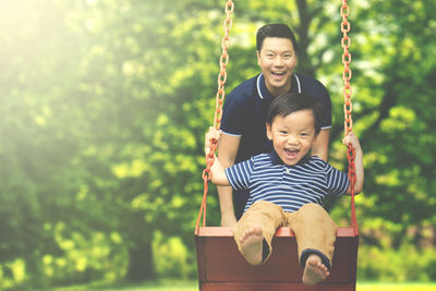 Father with son enjoying swing at park