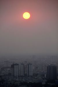 Scenic view of sea and buildings against sky during sunset