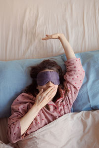 High angle view of woman lying on bed at home