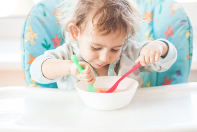 Baby girl eating food on table