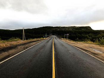 Empty road along countryside landscape