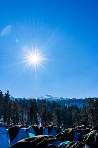 Scenic view of snowcapped mountains against blue sky on sunny day