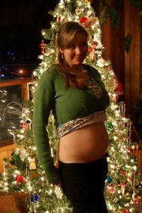 Woman on illuminated christmas tree