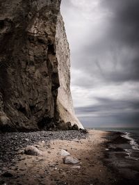 Rock formation at beach against sky