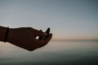 Midsection of person against sky during sunset