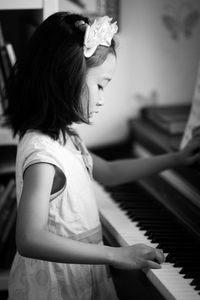 Side view of girl playing piano