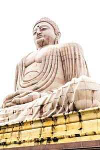 Low angle view of statue against temple against clear sky