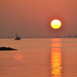 Scenic view of sea against orange sky