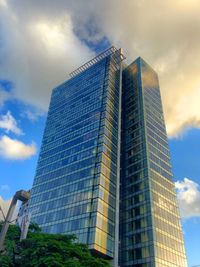 Low angle view of modern building against cloudy sky