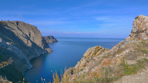 Scenic view of sea and rocks against blue sky