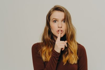 Portrait of young woman against white background