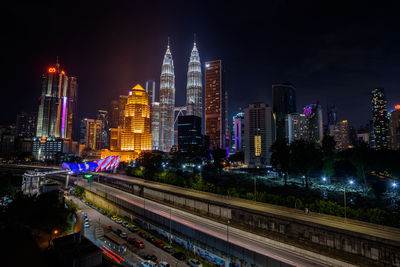 Illuminated buildings in city against sky at night