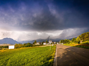 Road amidst field against sky