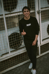 Portrait of a smiling young man standing against building